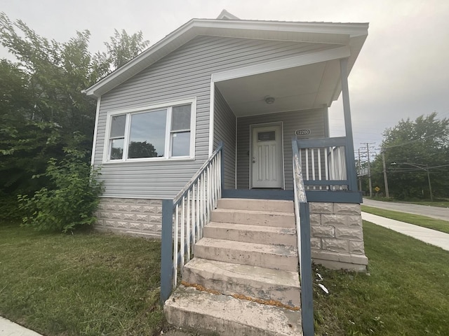 12200 S Lowe Ave, Chicago, IL 60628 - view of front of home with a front lawn and covered porch