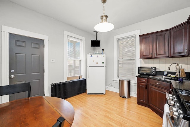 1637 N Keeler Ave, Chicago, IL 60639 - kitchen with freestanding refrigerator, dark countertops, light wood-type flooring, tasteful backsplash, and stainless steel gas stove