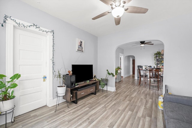 1637 N Keeler Ave, Chicago, IL 60639 - living room featuring arched walkways, a ceiling fan, and light wood-style flooring