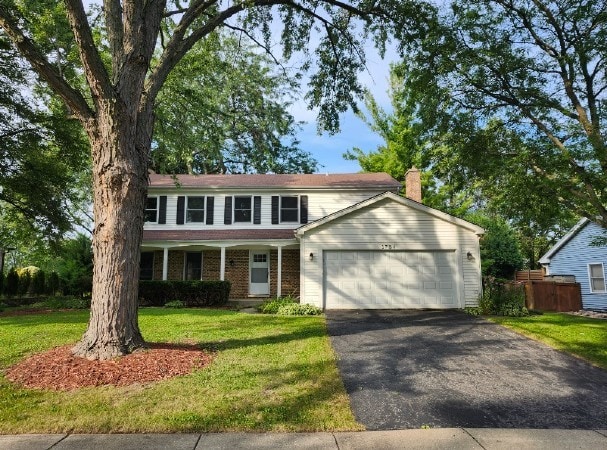 1734 Bishop Way, Mundelein, IL 60060 - traditional-style home with driveway, a chimney, an attached garage, a front yard, and brick siding