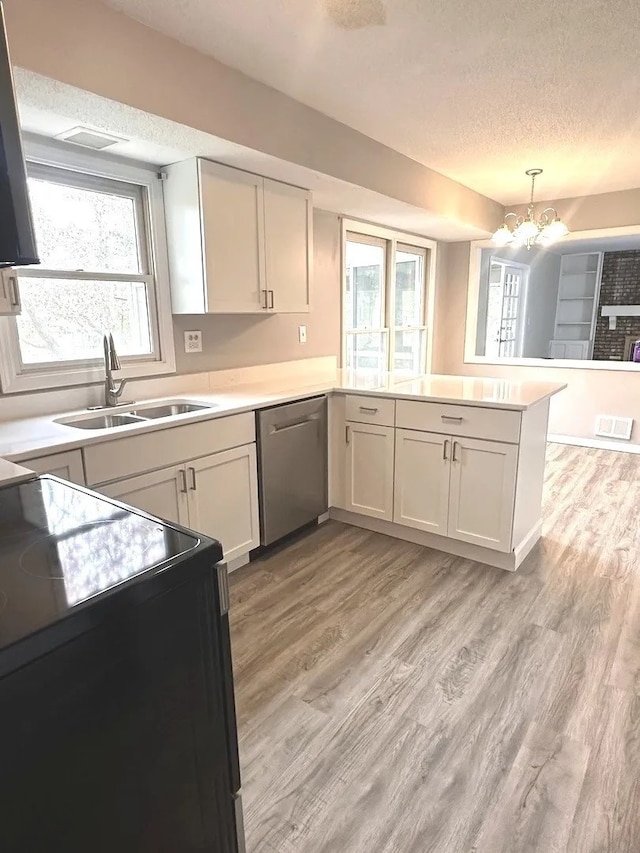1734 Bishop Way, Mundelein, IL 60060 - kitchen featuring black / electric stove, a peninsula, a textured ceiling, light wood-type flooring, and dishwasher