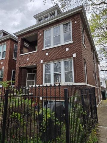 4457 S Sacramento Ave, Chicago, IL 60632 - view of front of property with brick siding, a balcony, and a fenced front yard