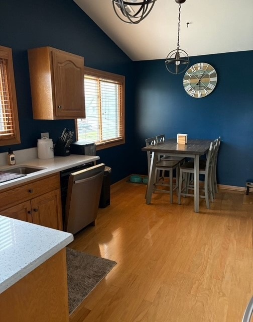 8310 Auburn Ln, Frankfort, IL 60423 - kitchen featuring vaulted ceiling, light countertops, light wood-type flooring, stainless steel dishwasher, and pendant lighting