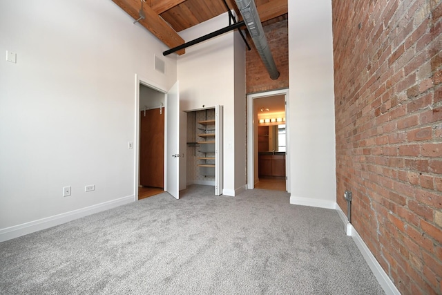 770 W Gladys Ave Unit 606, Chicago, IL 60661 - unfurnished bedroom with carpet flooring, a towering ceiling, brick wall, a wooden ceiling with exposed beams, and ensuite bathroom