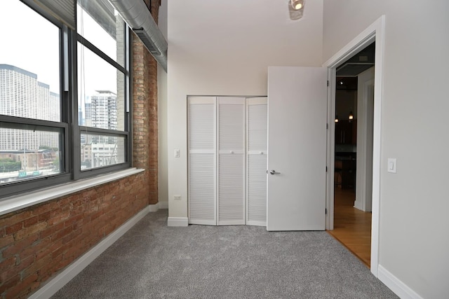 770 W Gladys Ave Unit 606, Chicago, IL 60661 - unfurnished bedroom with multiple windows, carpet, brick wall, and a closet