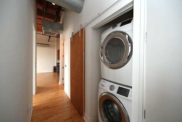 770 W Gladys Ave Unit 606, Chicago, IL 60661 - washroom featuring estacked washer and dryer and light wood-style flooring