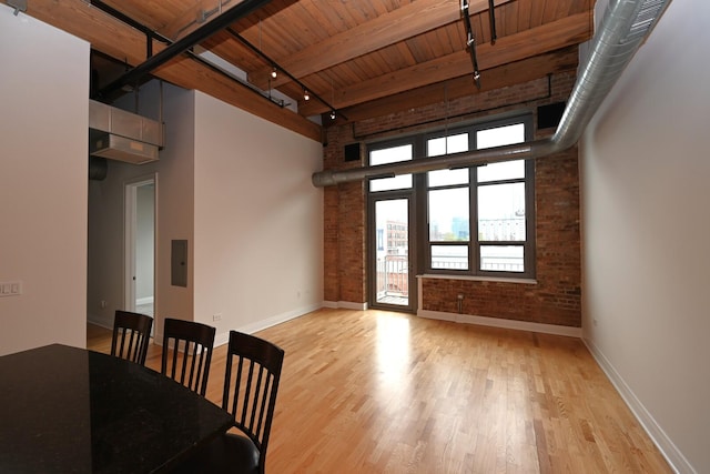 770 W Gladys Ave Unit 606, Chicago, IL 60661 - unfurnished living room with a wooden ceiling with exposed beams, a towering ceiling, rail lighting, wood finished floors, and brick wall