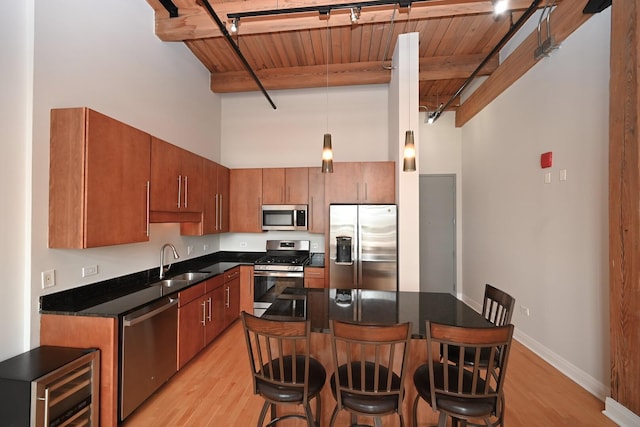 770 W Gladys Ave Unit 606, Chicago, IL 60661 - kitchen with a wood ceiling with exposed beams, appliances with stainless steel finishes, light wood-type flooring, a kitchen breakfast bar, and a towering ceiling