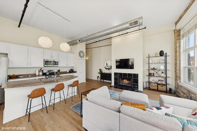 1907 N Milwaukee Ave Unit 307, Chicago, IL 60647 - living area with a high ceiling, a tile fireplace, light wood-type flooring, and rail lighting