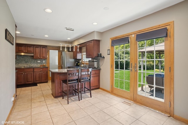 523 N Ela Rd, Barrington, IL 60010 - kitchen featuring a peninsula, backsplash, light tile patterned floors, a kitchen breakfast bar, and hanging light fixtures
