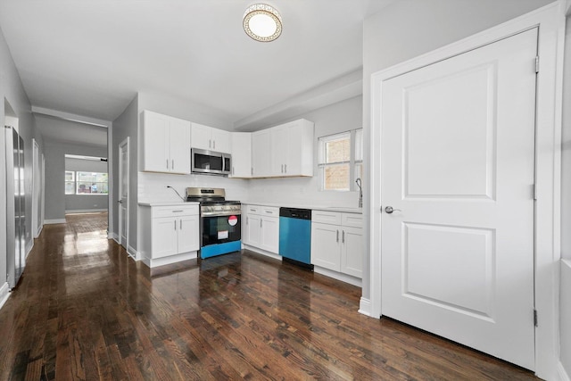 4426 S Artesian Ave, Chicago, IL 60632 - kitchen featuring stainless steel appliances, white cabinets, light countertops, dark wood-style flooring, and backsplash