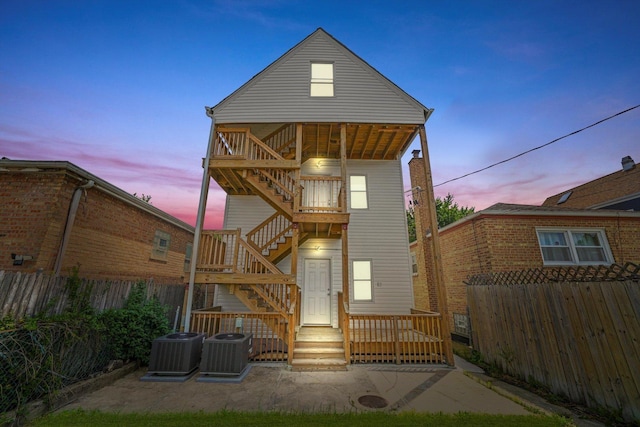 4426 S Artesian Ave, Chicago, IL 60632 - back of property at dusk featuring stairway, a fenced backyard, a patio area, and a deck