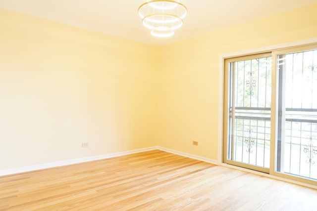2665 W Warren Blvd Unit 3, Chicago, IL 60612 - empty room featuring a chandelier, light wood finished floors, and plenty of natural light