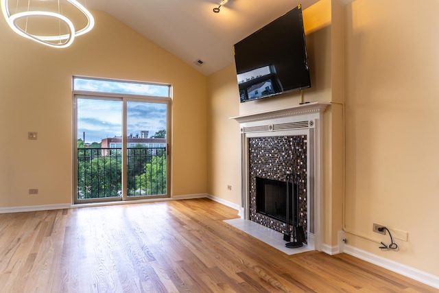 2665 W Warren Blvd Unit 3, Chicago, IL 60612 - unfurnished living room with a tile fireplace, wood finished floors, a chandelier, and high vaulted ceiling