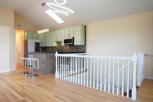 2665 W Warren Blvd Unit 3, Chicago, IL 60612 - kitchen with green cabinets, dark countertops, backsplash, white appliances, and vaulted ceiling