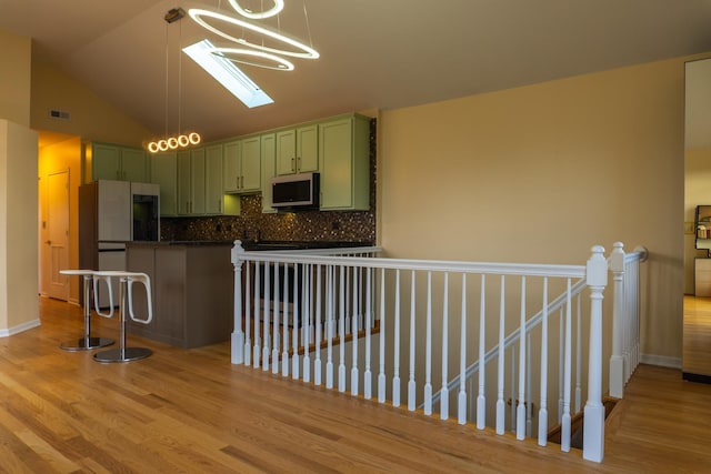 2665 W Warren Blvd Unit 3, Chicago, IL 60612 - kitchen with green cabinets, dark countertops, light wood-style floors, and lofted ceiling
