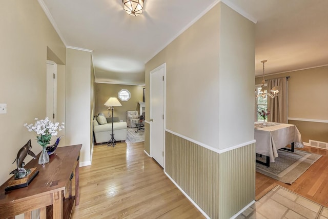 859 S Mount Prospect Rd, Des Plaines, IL 60016 - hallway featuring a chandelier, crown molding, light wood finished floors, and plenty of natural light