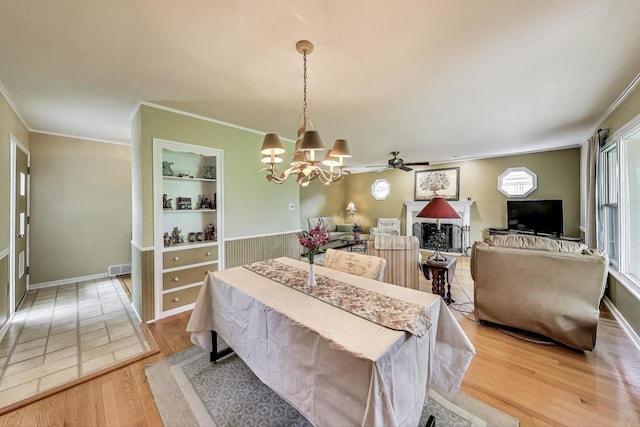 859 S Mount Prospect Rd, Des Plaines, IL 60016 - dining room featuring light wood-type flooring, a chandelier, built in shelves, crown molding, and a fireplace