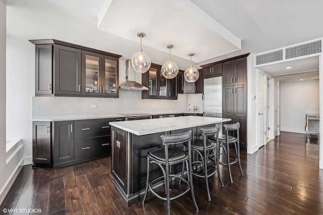 260 E Chestnut St Unit 1210, Chicago, IL 60611 - kitchen with wall chimney range hood, dark wood-style floors, decorative backsplash, and glass insert cabinets