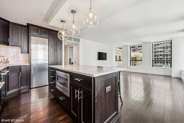 260 E Chestnut St Unit 1210, Chicago, IL 60611 - kitchen featuring dark wood-type flooring, built in appliances, light stone countertops, tasteful backsplash, and a kitchen island