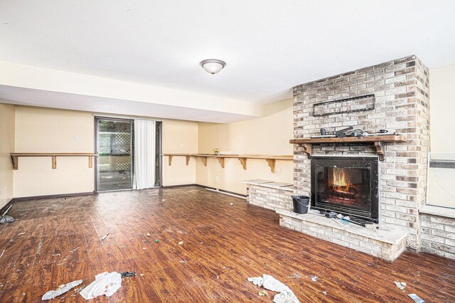 3038 225th St, Sauk Village, IL 60411 - unfurnished living room with a brick fireplace and wood-type flooring