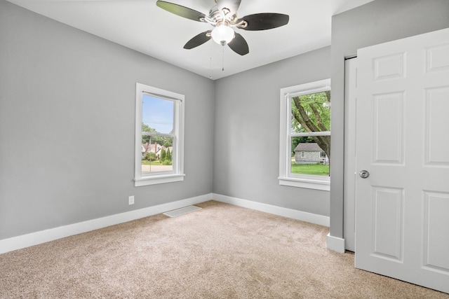 526 S Calumet Ave, Aurora, IL 60506 - empty room featuring light colored carpet, plenty of natural light, and ceiling fan