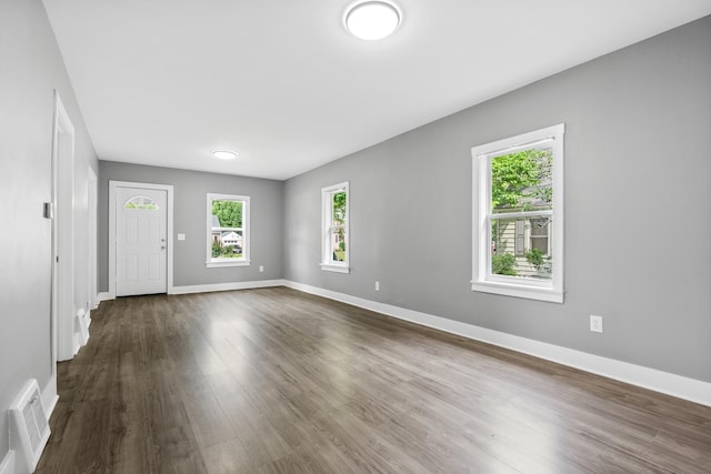 526 S Calumet Ave, Aurora, IL 60506 - unfurnished living room featuring baseboards and dark wood-style floors