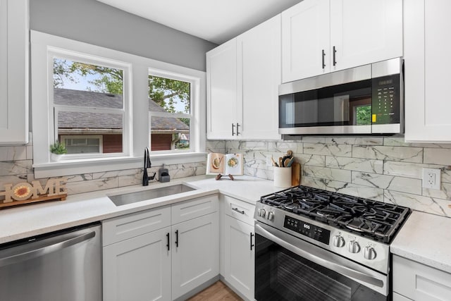 526 S Calumet Ave, Aurora, IL 60506 - kitchen featuring appliances with stainless steel finishes, white cabinetry, and decorative backsplash