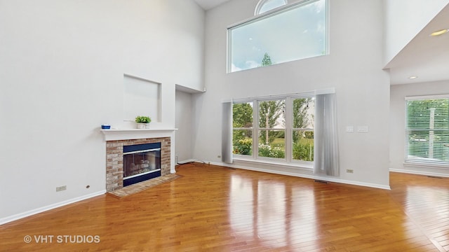 1291 White Chapel Ln, Algonquin, IL 60102 - unfurnished living room featuring wood finished floors, a fireplace, and a towering ceiling