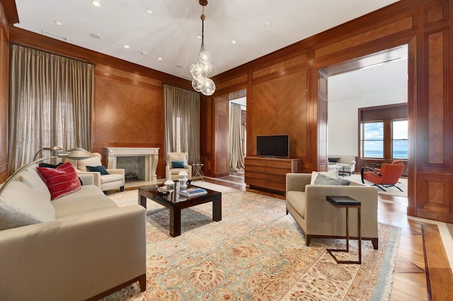 189 E Lake Shore Dr Unit Ph18, Chicago, IL 60611 - living room with a fireplace, wooden walls, light wood-style flooring, recessed lighting, and crown molding