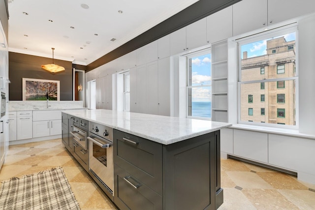 189 E Lake Shore Dr Unit Ph18, Chicago, IL 60611 - kitchen featuring light stone countertops, white cabinetry, stainless steel oven, a kitchen island, and pendant lighting