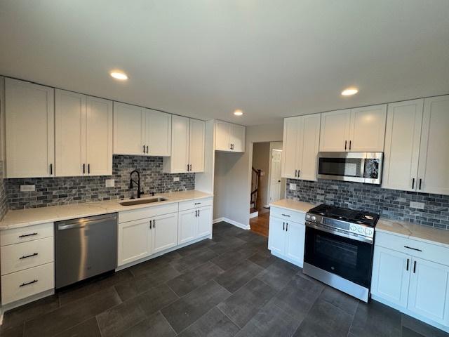 535 Florian Dr, Des Plaines, IL 60016 - kitchen featuring stainless steel appliances, white cabinetry, light countertops, tasteful backsplash, and recessed lighting