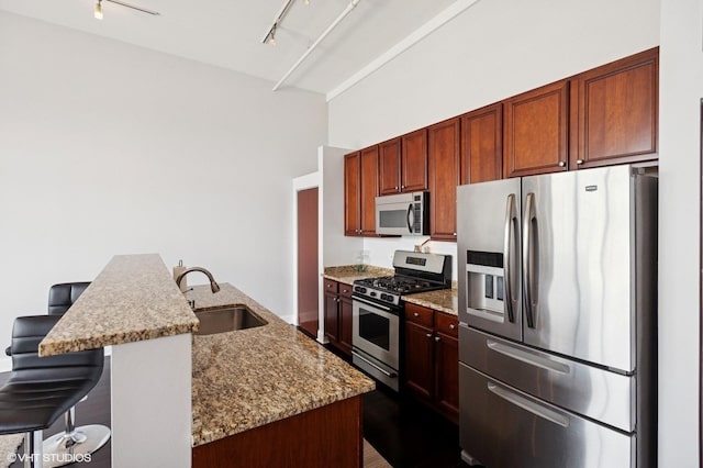 1524 S Sangamon St Unit 802, Chicago, IL 60608 - kitchen featuring appliances with stainless steel finishes, track lighting, light stone counters, a breakfast bar, and a center island with sink