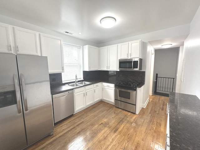 3707 W Altgeld St Unit 1, Chicago, IL 60647 - kitchen with stainless steel appliances, white cabinetry, decorative backsplash, and light wood finished floors