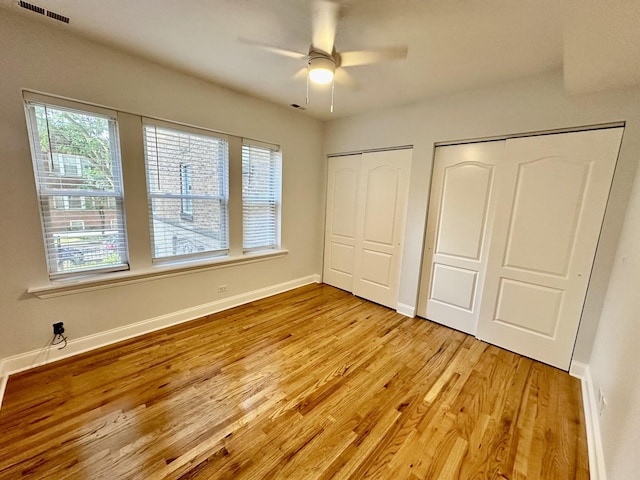 3707 W Altgeld St Unit 1, Chicago, IL 60647 - unfurnished bedroom with multiple closets, light wood finished floors, and ceiling fan
