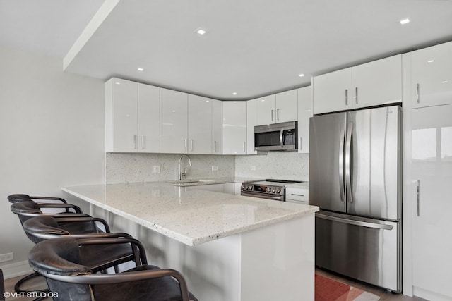 4800 S Chicago Beach Dr Unit 503N, Chicago, IL 60615 - kitchen featuring stainless steel appliances, a peninsula, light stone countertops, white cabinetry, and recessed lighting