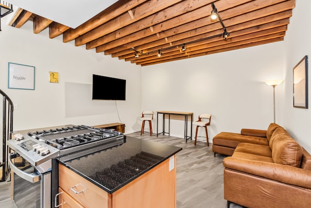 7349 Madison St Unit C, Forest Park, IL 60130 - kitchen featuring rail lighting, stainless steel range with gas cooktop, open floor plan, dark stone countertops, and light brown cabinetry