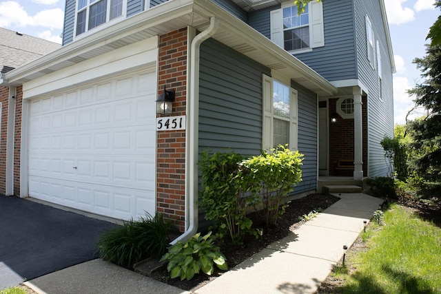 5451 Elizabeth Pl Unit 0, Rolling Meadows, IL 60008 - view of property exterior featuring brick siding, driveway, and an attached garage