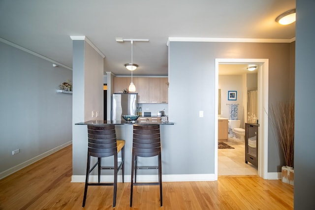 225 N Columbus Dr Unit 7207, Chicago, IL 60601 - kitchen featuring a kitchen bar, freestanding refrigerator, ornamental molding, dark countertops, and decorative light fixtures