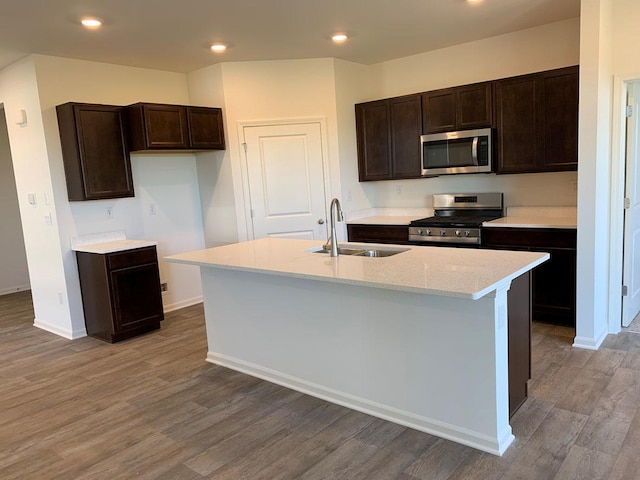 2296 Laurel Ct, Wonder Lake, IL 60097 - kitchen with appliances with stainless steel finishes, dark brown cabinets, wood finished floors, an island with sink, and recessed lighting