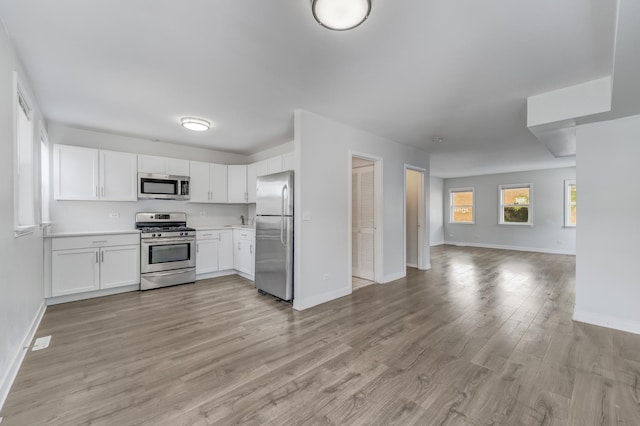 1166 W Cullerton St, Chicago, IL 60608 - kitchen with open floor plan, appliances with stainless steel finishes, white cabinetry, light wood-style flooring, and light countertops
