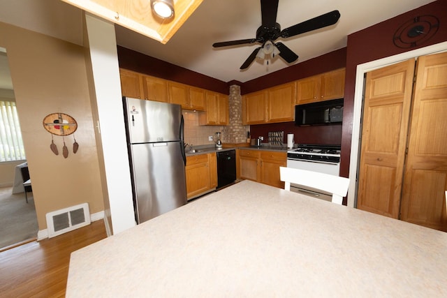 1406 Portsmouth Ave, Westchester, IL 60154 - kitchen featuring black appliances, ceiling fan, wood finished floors, decorative backsplash, and vaulted ceiling