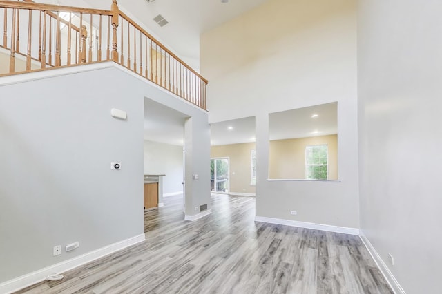 574 S Jade Ln, Round Lake, IL 60073 - unfurnished living room featuring wood finished floors and a high ceiling