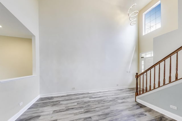 574 S Jade Ln, Round Lake, IL 60073 - unfurnished living room with wood finished floors, stairs, and a towering ceiling