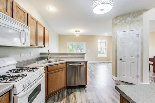 574 S Jade Ln, Round Lake, IL 60073 - kitchen with white appliances, wood finished floors, brown cabinetry, a peninsula, and light countertops