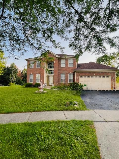 2705 Westwood Cir, Carpentersville, IL 60110 - view of front of house featuring driveway, brick siding, a front lawn, and an attached garage