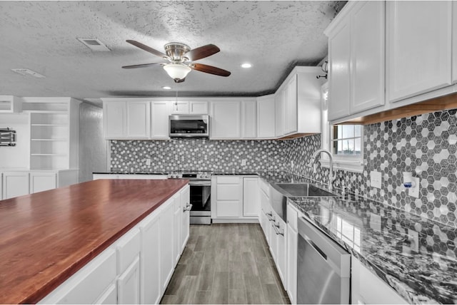 kitchen featuring visible vents, stainless steel appliances, and white cabinetry