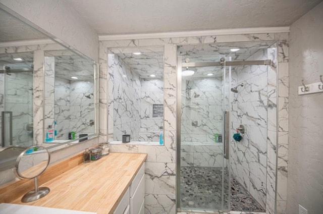 full bathroom featuring a textured ceiling, a marble finish shower, vanity, and tile walls