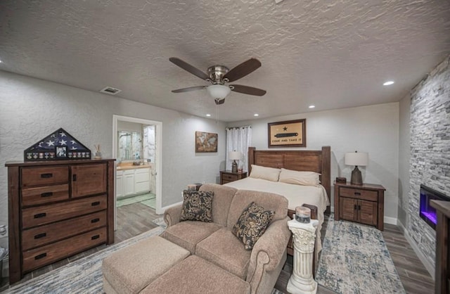 bedroom with a textured ceiling, recessed lighting, visible vents, and light wood-style floors