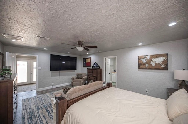 bedroom with recessed lighting, visible vents, a textured wall, a textured ceiling, and wood finished floors